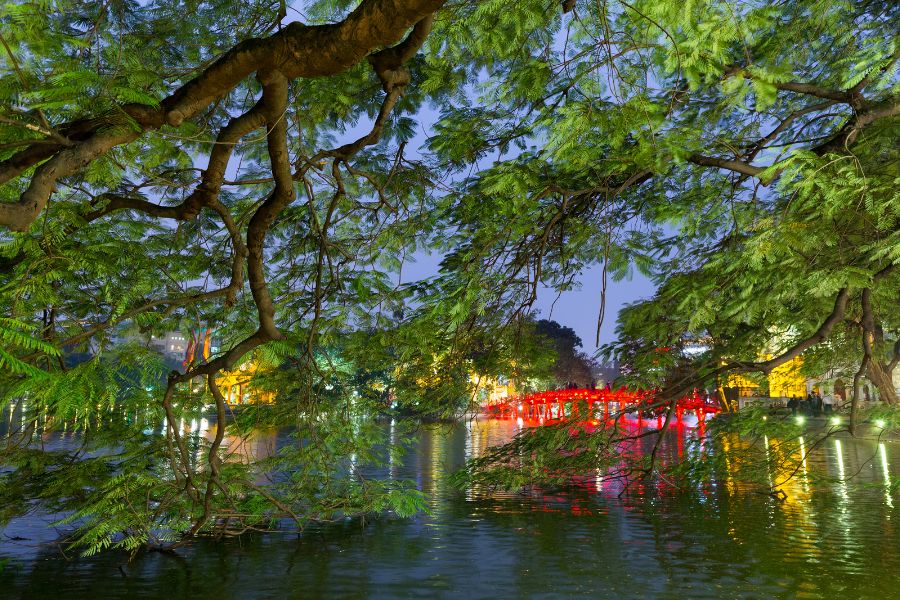 Luxury Vietnam Itinerary evening view of Hoan Kiem Lake with red bridge and ancient trees