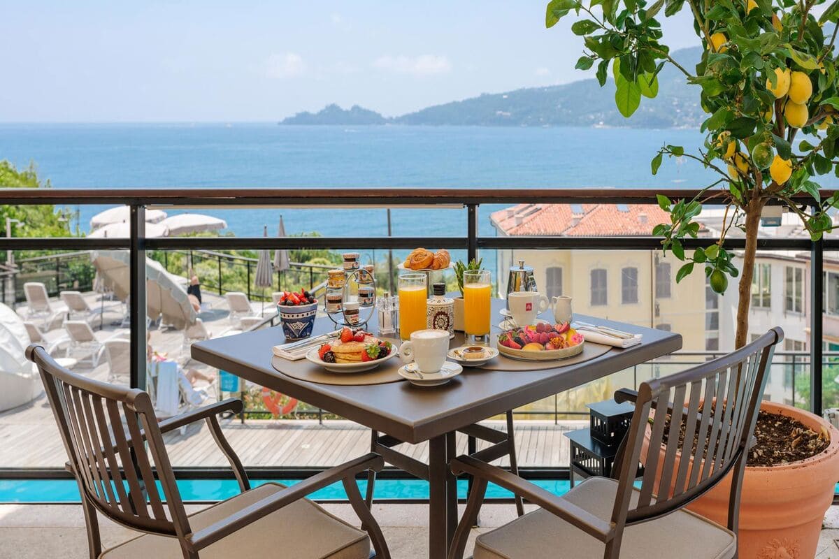 Breakfast with fruit, pastries and juice on a terrace overlooking the sea