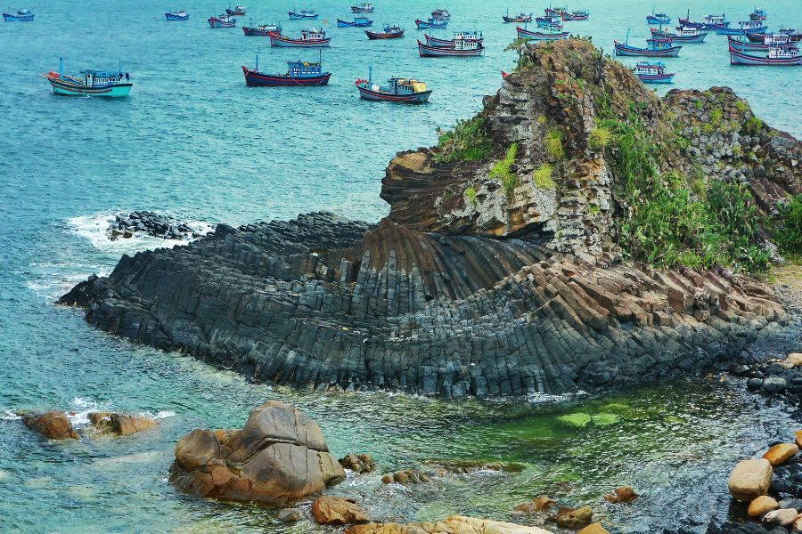 stunning rock formations and fishing boats at Phu Yen coastline Vietnam Luxury Tours